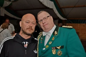 Traditioneller Schützenbruder im grünen Uniform mit Medaillen bei Sebastianus & Afra Schützenbruderschaft in Köln.