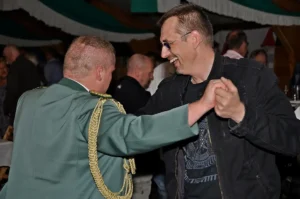 Fröhliche Männer beim Tanz bei den Sebastianus & Afra Schützen in Köln, traditionelles Fest, festliche Stimmung, Freude und Gemeinschaft, Schützenbruderschaft, Feierlichkeiten.