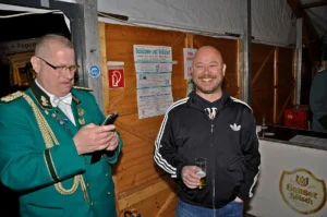 Traditioneller Schützenverein bei einem Fest in Köln, zwei Männer lachen und feiern.