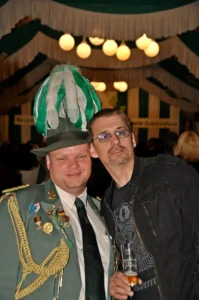 Herren in traditioneller Schützenuniform mit Zeltdach-Hut bei einem Fest in Köln.