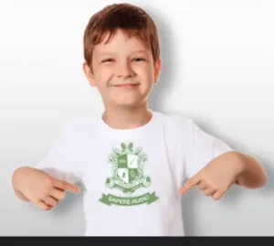 Ein Junge trägt ein weißes T-Shirt mit dem Motto "Sapere Aude" und zeigt nach unten, symbolisiert Stolz und Gemeinschaft der Sebastianus & Afra Schützenbruderschaft.